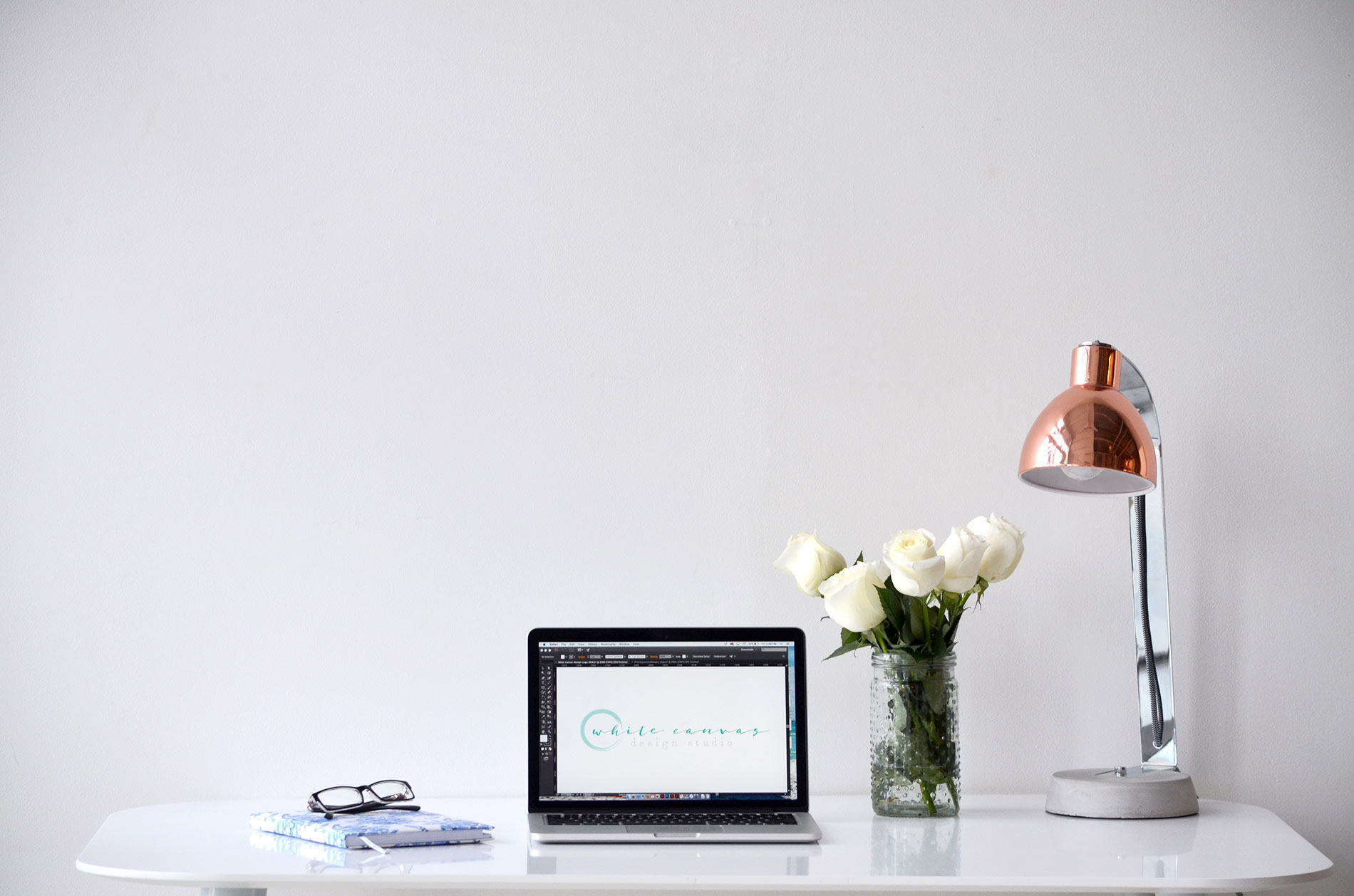 Desktop with laptop, lamp, and flowers