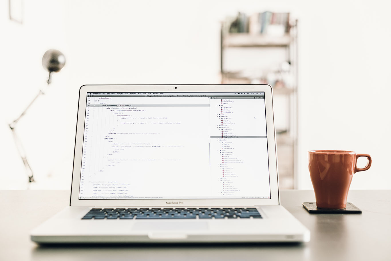 code in a computer with a cup on the table - White Canvas Design