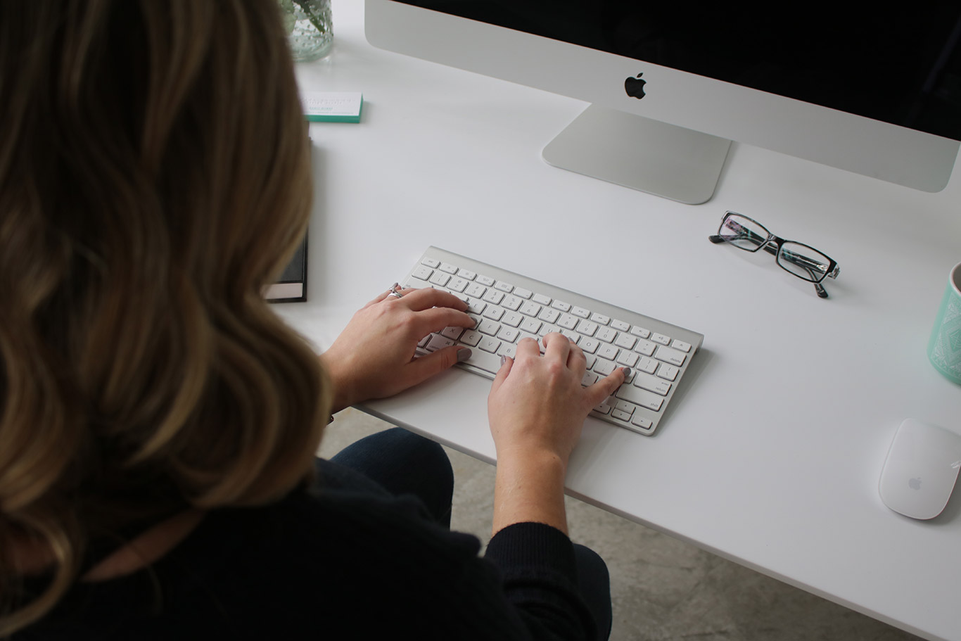 woman typing on a keyboard - White Canvas Design