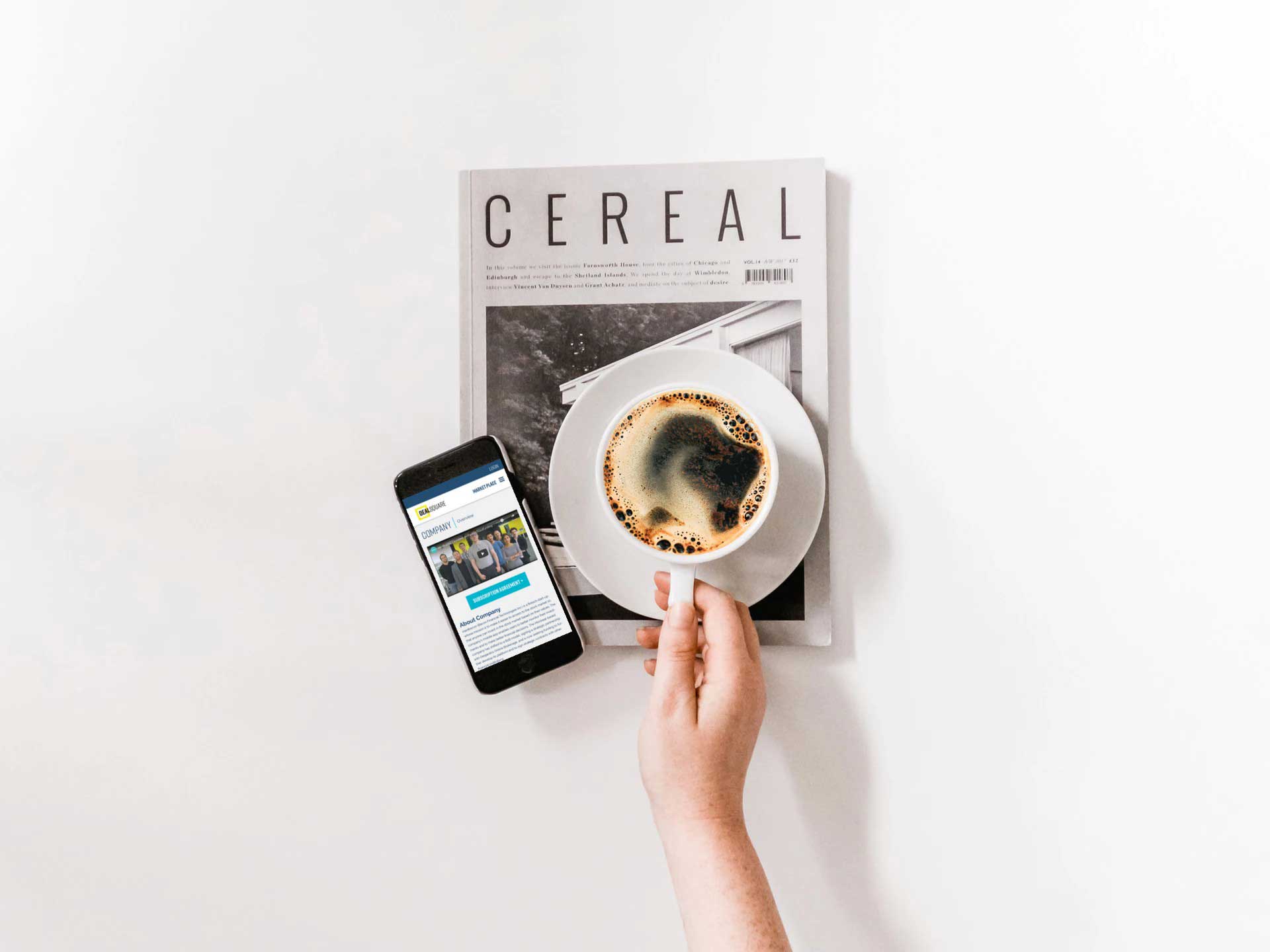 Deal Square website on a mobile device beside a magazine and a cup of coffee - White Canvas Design