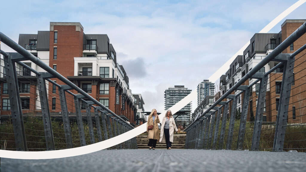 Vesta North Village two women walking in front of a building render across a bridge