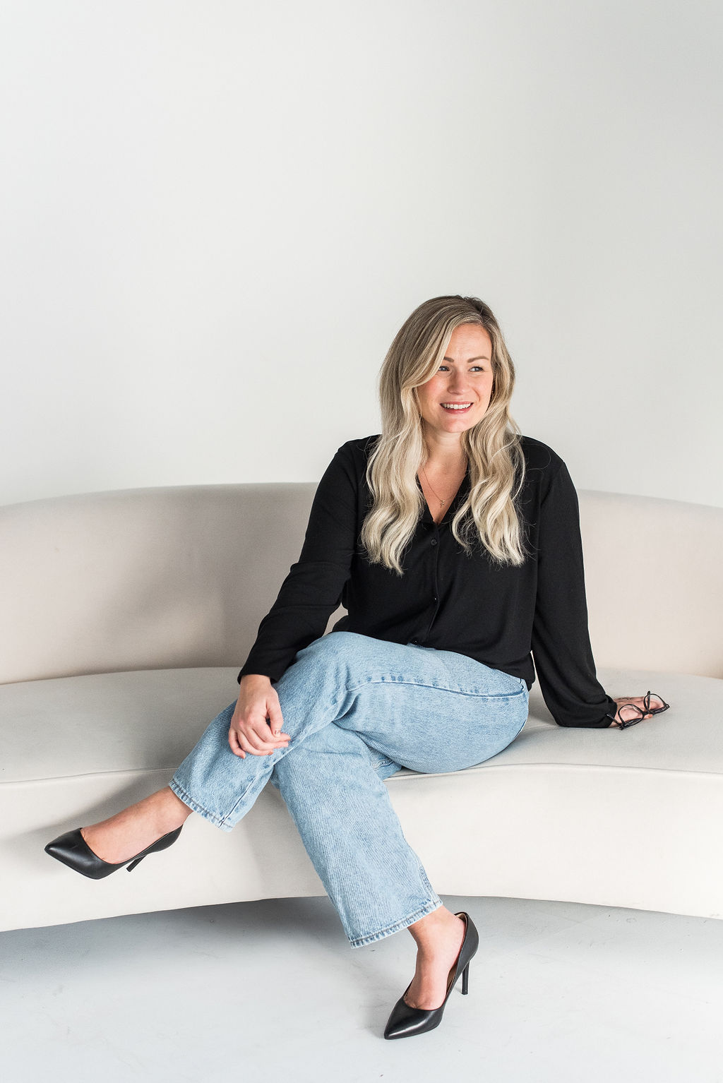 Carly sitting on a white couch