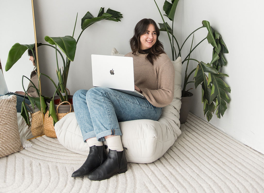 Terra sitting on a chair holding a laptop