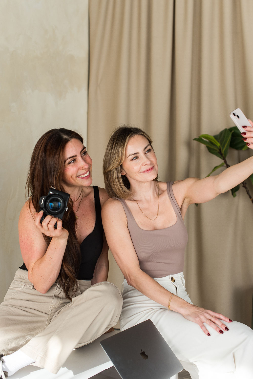 Tania and Kelsey smiling taking photos for social media