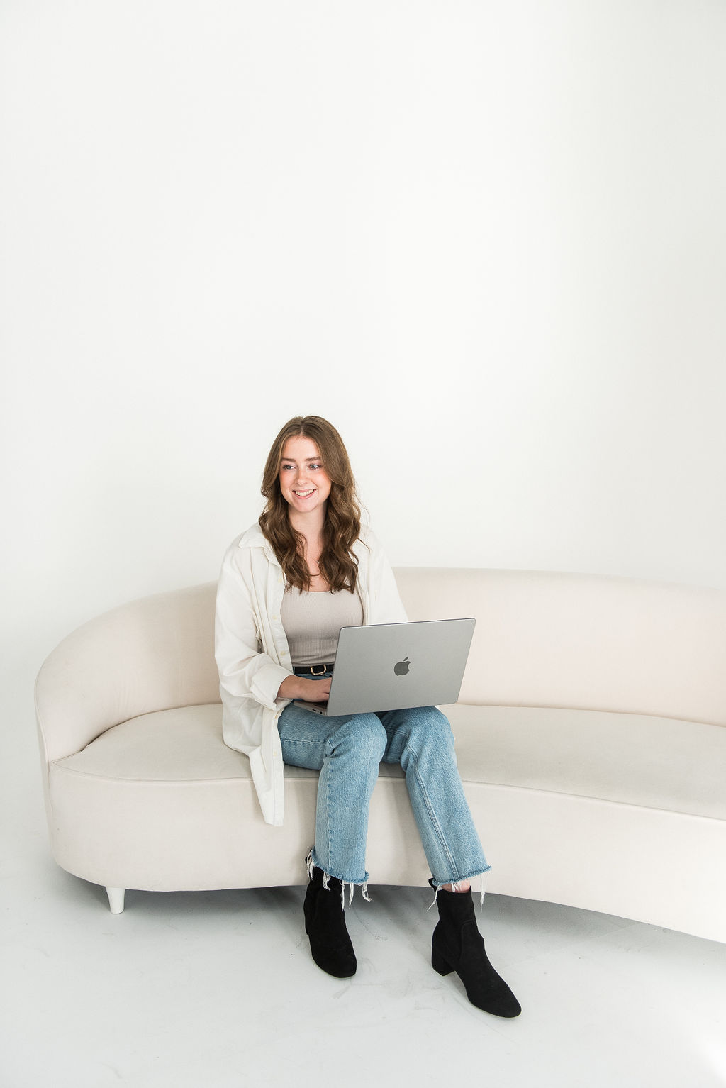 Cass sitting on a couch with a laptop