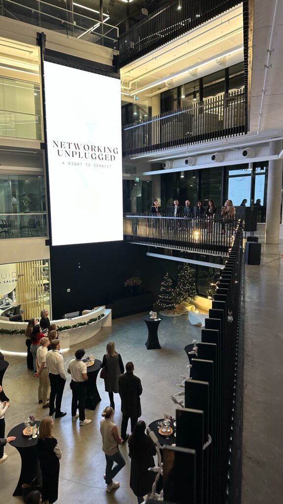 A panel of speakers sitting on a mezzanine speaking at the Networking unplugged event